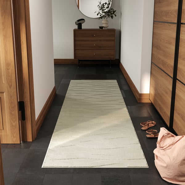 White VÄXELFEL rug in hallway, fits under dresser, by shoes.