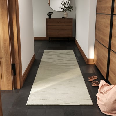 White VÄXELFEL rug in hallway, fits under dresser, by shoes.