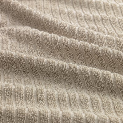 Close-up of soft, textured beige towel, showcasing its luxe, absorbent fabric.