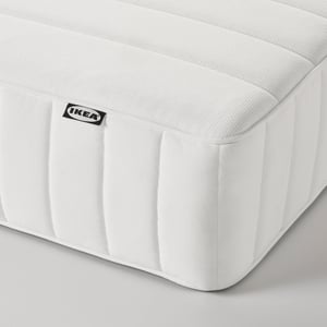 Close-up of a pristine white IKEA mattress with fabric quilted evenly, showcasing its high-quality texture and comfort layers.