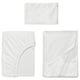 Three white cotton sheets laid flat, including a fitted sheet, flat sheet, and pillowcase, showcasing jersey knit texture and elastic edges.