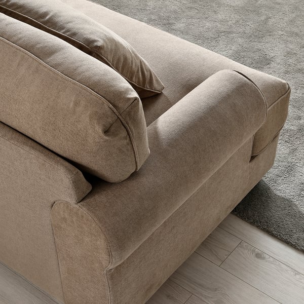 A cosy, beige sofa with plush cushions and high backrests, offering inviting comfort.