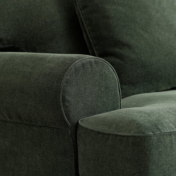Close-up of luxuriously upholstered green sofa with smooth, rounded edges and plush fabric.