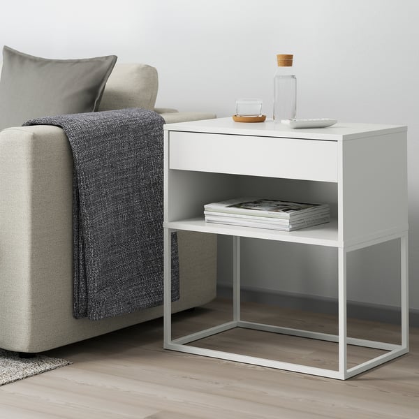 White VIKHAMMER side table with drawer and shelf next to grey chair, sleek design.