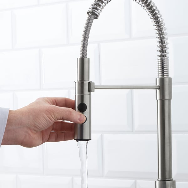 A hand turns on a modern VIMMERN tap, demonstrating its easy-to-use magnetic handspray for flexible water flow.