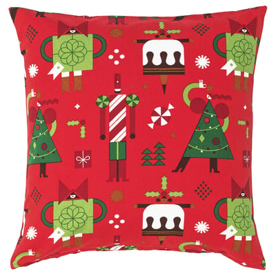 Red square throw pillow with holiday motifs including christmas trees, nutcrackers, and cake. Made of cotton.