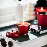 VINTERFINT Scented candle in metal cup, apple-shaped/Apple and cinnamon red, 24 hr
