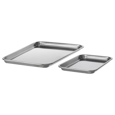 Two stainless steel baking trays, one larger, one smaller, both rectangular with raised edges, placed diagonally against a white background.