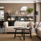 Modern living room with beige VISKAFORS sofa, black coffee table, and black accents; beige carpet and walls, plants, and mirror.