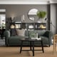 Modern living room with a VISKAFORS sofa, grey cushions, black coffee table, and dark shelves with books and decorations.