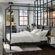 YTTERVÅG queen bed: black metal posts, white sheets, high headboard, modern style, near large window, with bedside table and rug.