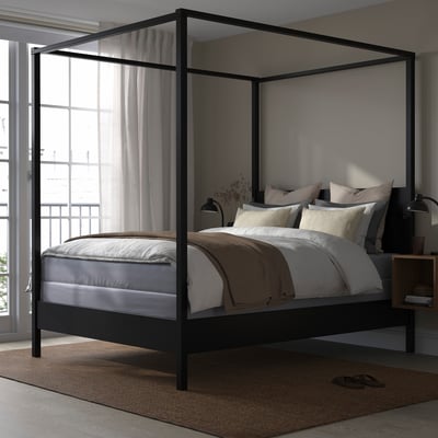 Modern metal bed with canopy; sleek black frame, large windows, white curtains; large or king size.