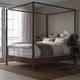 Modern YTTERVÅG four-poster bed with wooden frame and high headboard, creating a focal point in a minimalist bedroom design.