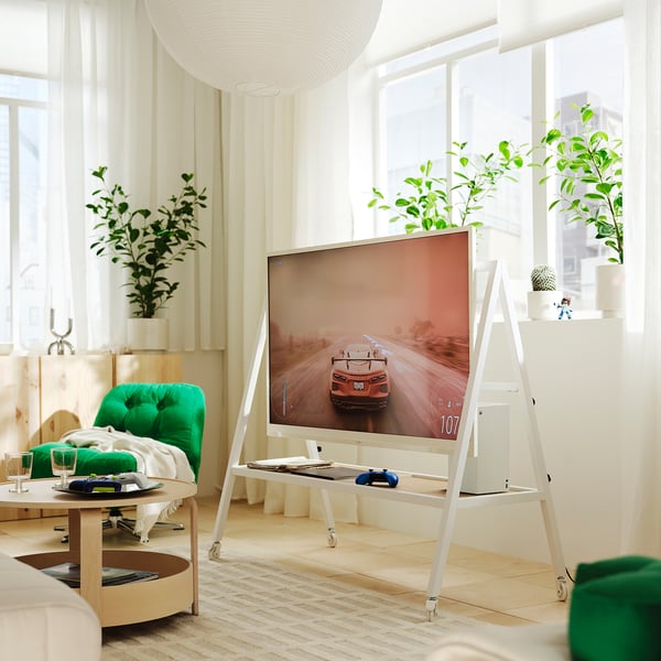 White IKEA YXSTABY tv stand with gaming setup in bright living room.
